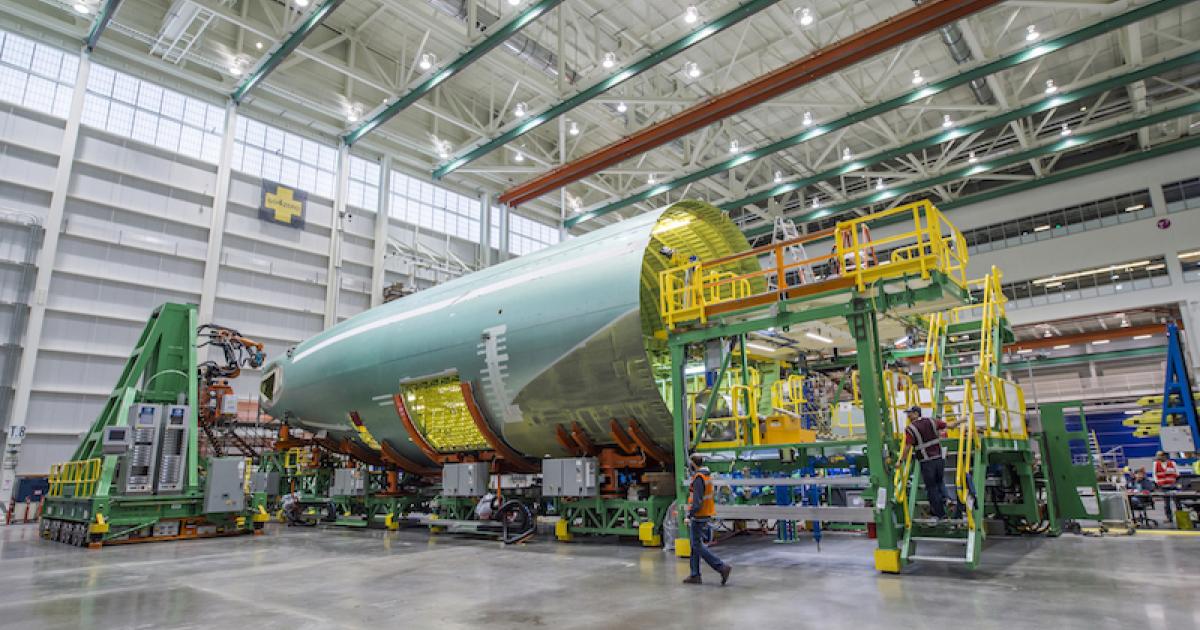 A 777 aft fuselage sits in cradles as a robot stands ready to drill and fasten panel sections in the FAUB bay at Boeing's Everett, Washington, final assembly plant. (Photo: Boeing)  
