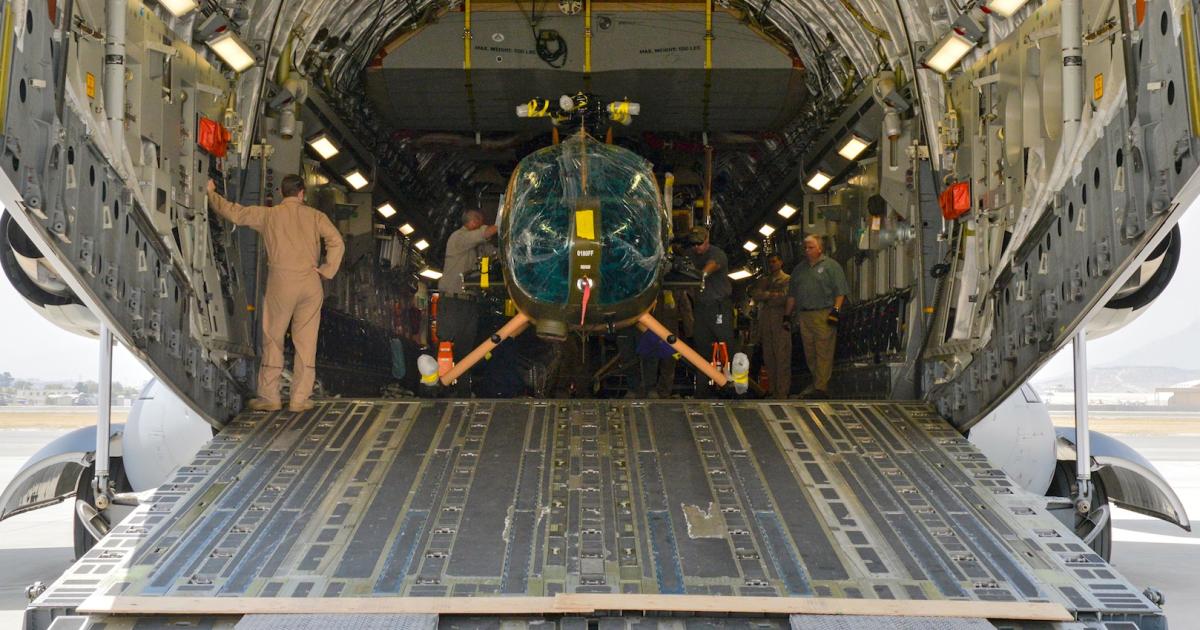 Airmen unload one of final four MD 530F Cayuse Warriors for Afghanistan from a C-17 airlifter on August 25. (Photo: U.S. Air Force)