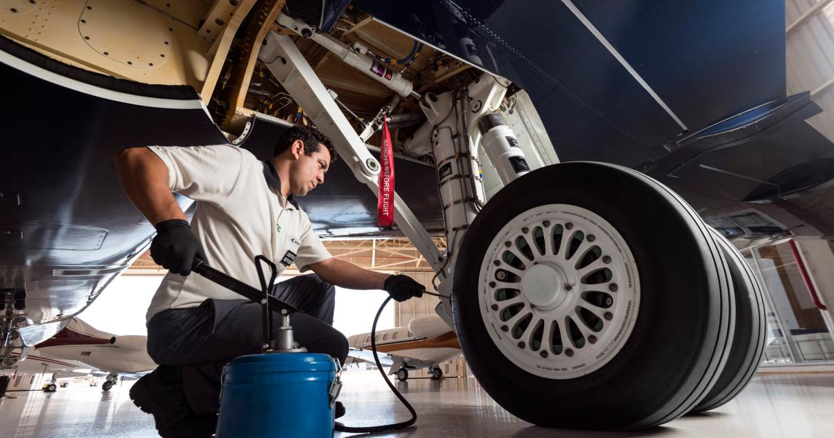 A maintenance technician at Embraer Executive Jet's Sorocaba, Brazil service center services the landing gear on a Legacy 650. (Photo: Embraer)
