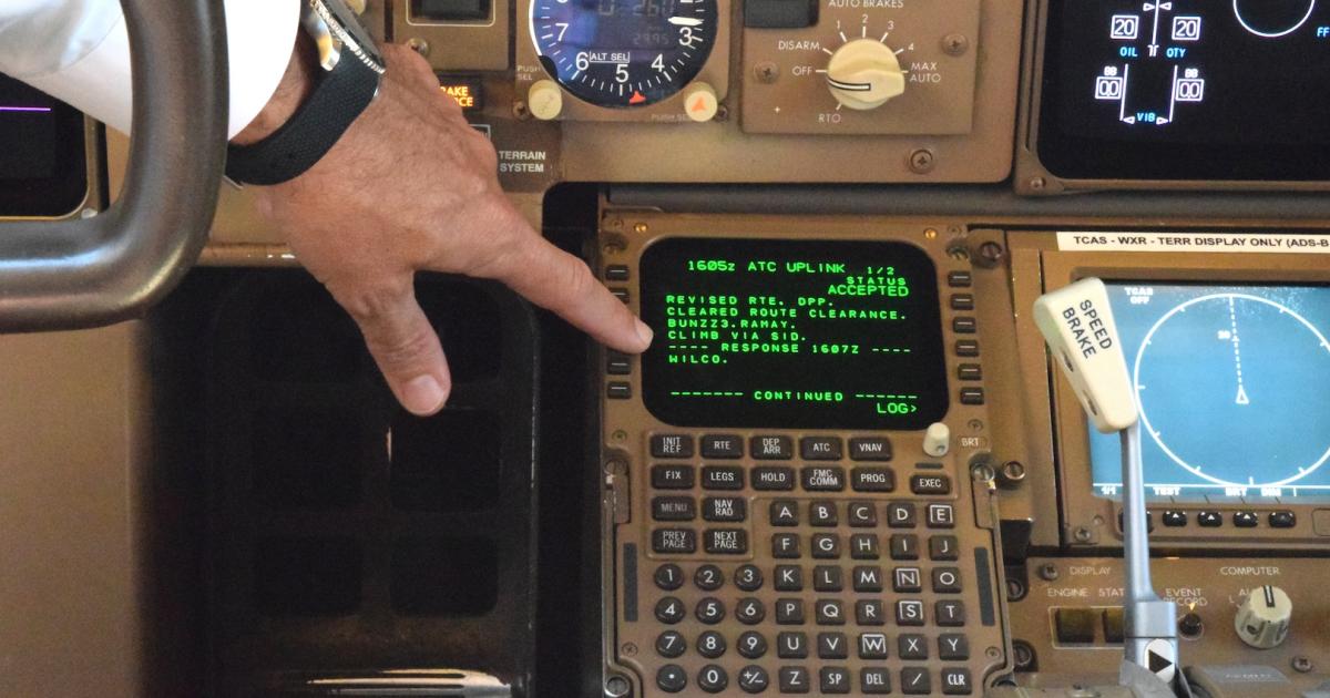 UPS captain Gregg Kastman points out a data message on the flight deck of a Boeing 767-300 freighter. (Photo: Bill Carey)