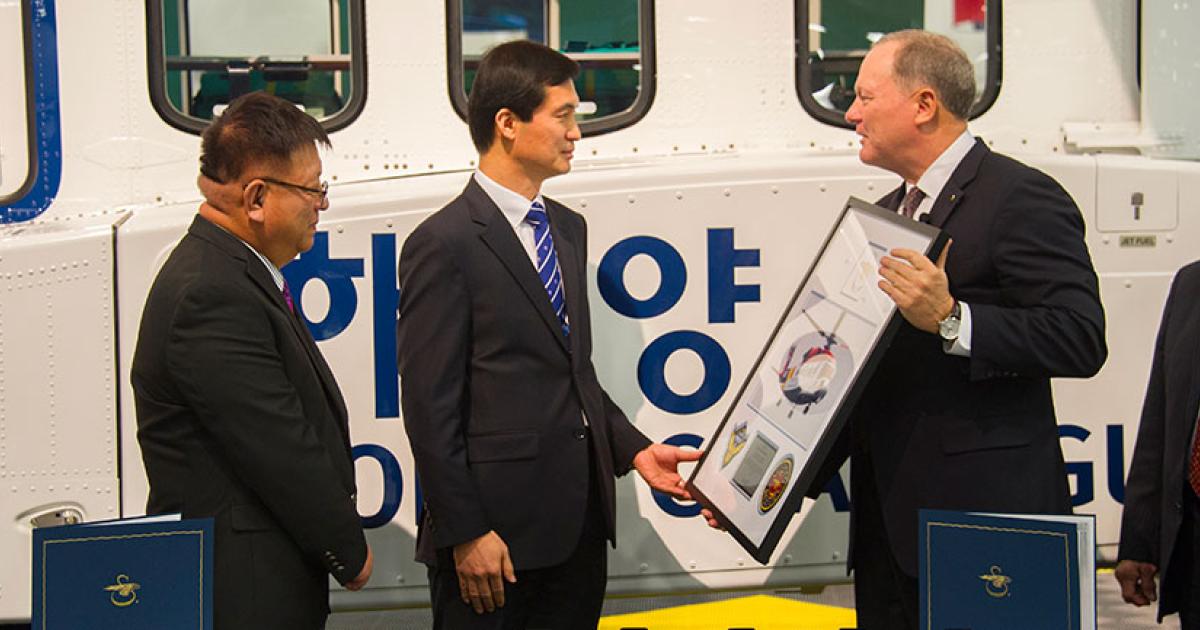 Sikorsky sales representative Sam Chae, Korea Coast Guard senior inspector Seong Chul Kim and Sikorsky president Dan Schultz mark the second S-92 going to the service. The aircraft on display at Sikorsky’s booth will officially be handed over to the coast guard following Heli-Expo.