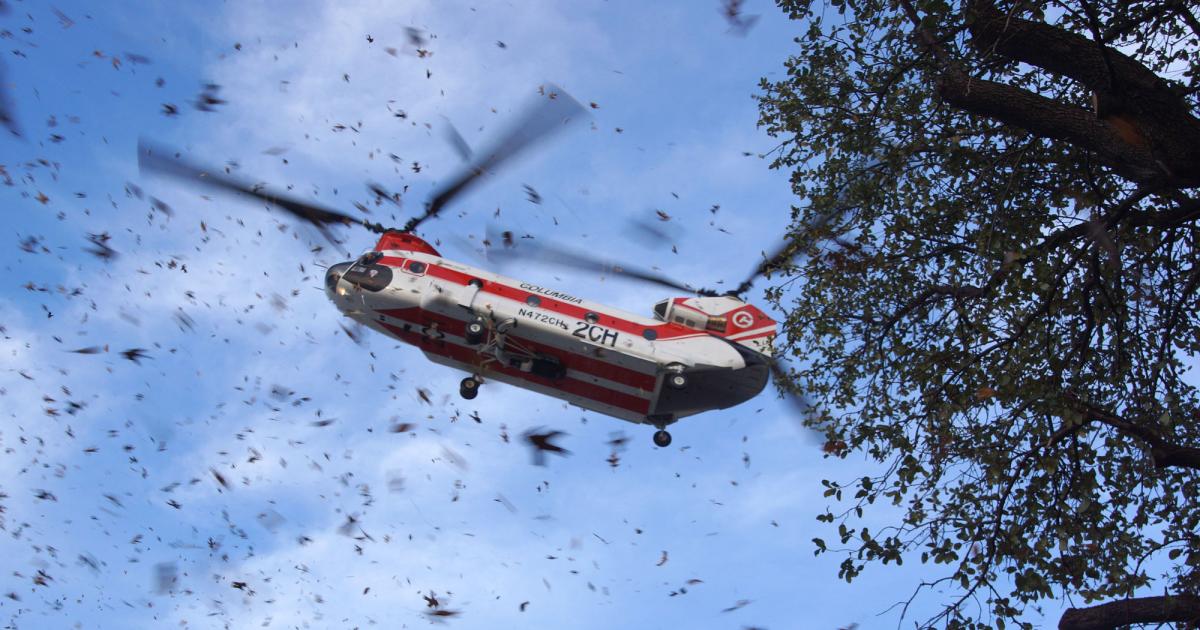 A Fire Attack System-equipped Columbia Helicopters CH-47D Chinook sent leaves blowing on its arrival here at Heli-Expo on Saturday. The big helicopter’s fire-suppression system has a 2,800-gallon water tank.  Photo: Matt Thurber