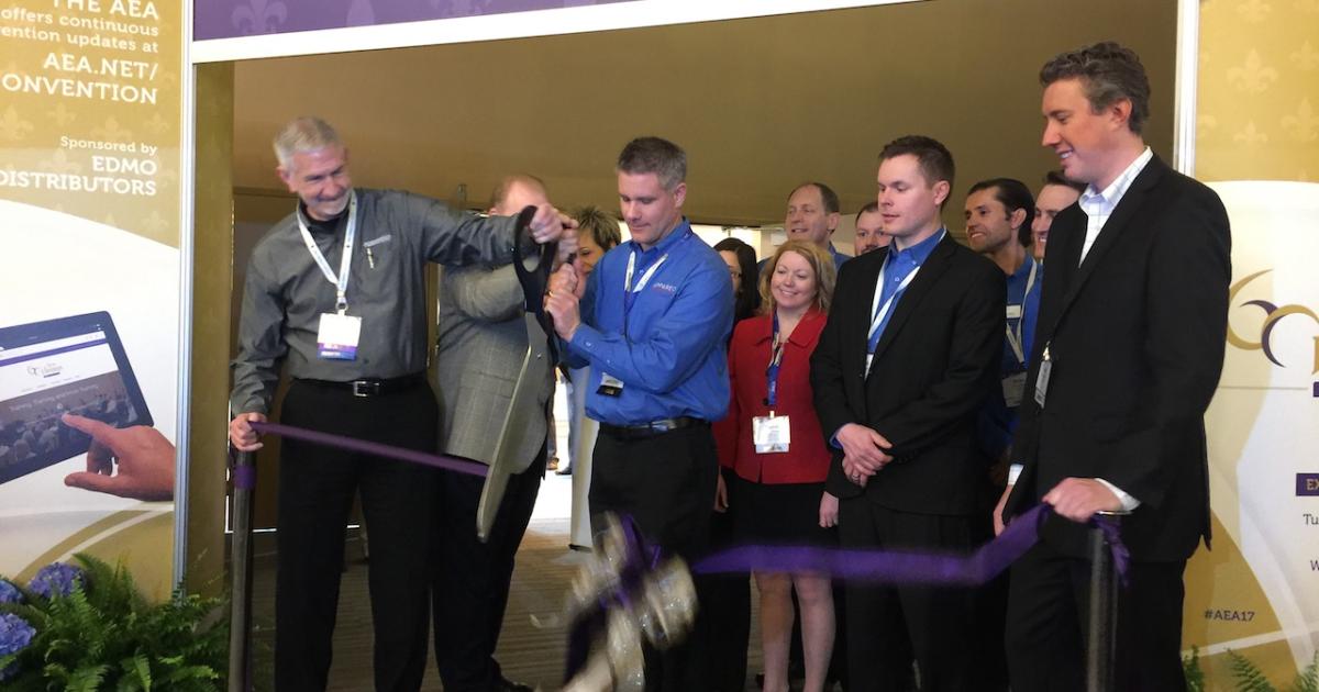 Flightstar avionics manager Greg Vail (left) and 2017 AEA member of the year cuts the exhibit hall opening ribbon with the Appareo team, winners of the AEA associate member of the year award. Photo: Matt Thurber