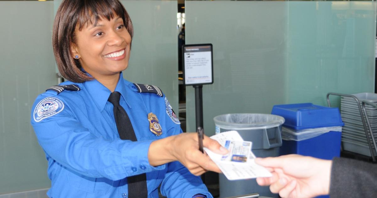 A Transportation Security Administration screener accepts passenger's identification at an airport security checkpoint. (Photo: TSA)