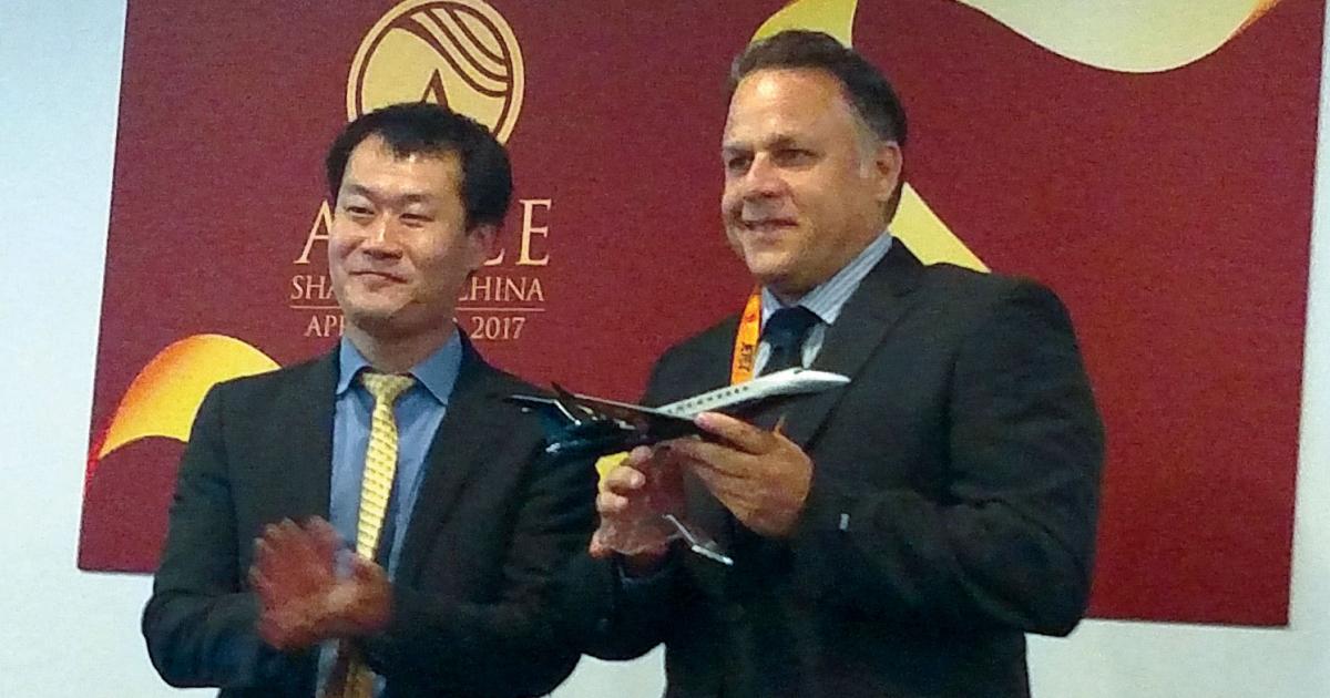 Wang Fuhou, v-p of aviation for Minsheng Financial Leasing celebrates with Bill Papariella, Jet Edge CEO.