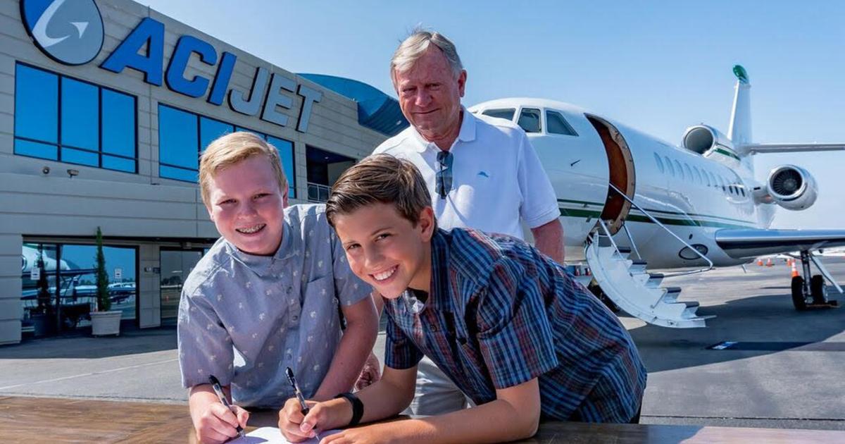 Tweens Gavin (left) and Jake sign a deal they negotiated for the latter's grandfather, John Dohlberg (in background), to base his Dassault Falcon 900 at ACI Jet at John Wayne Airport (SNA) in Orange County, California. Gavin is the son of a manager at ACI Jet. The two sixth graders met at the FBO during a school field trip and began drafting the hangar agreement soon after realizing an aviation connection. (Photo: ACI Jet)