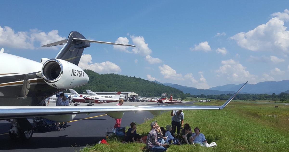 Passengers of this Flexjet Bombardier Challenger 350 sit under the wing as they wait to see solar eclipse totality on August 21 at Western Carolina Regional in Andrews, North Carolina. (Photo: Flexjet)