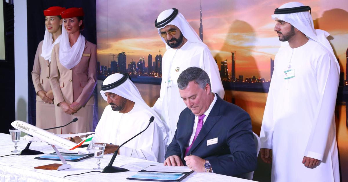 Shiekh Ahmed bin Saeed Al Maktoum, president of the Dubai Civil Aviation Authority and CEO and chairman of the  Emirates Group (left), and Boeing Commercial Airplanes president and CEO Kevin McAllister (right) sign an agreement for 40 787 Dreamliners as Sheikh Mohammed bin Rashid Al Maktoum, vice president and prime minister of the UAE, and ruler of the Emirate of Dubai (standing), looks on.