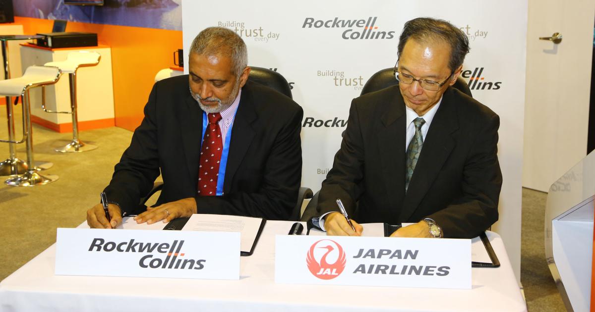 Heament John Kurian, left, of Rockwell Collins and Jun Sato of Japan Airlines sign a contract extension for ARINC AviNet.