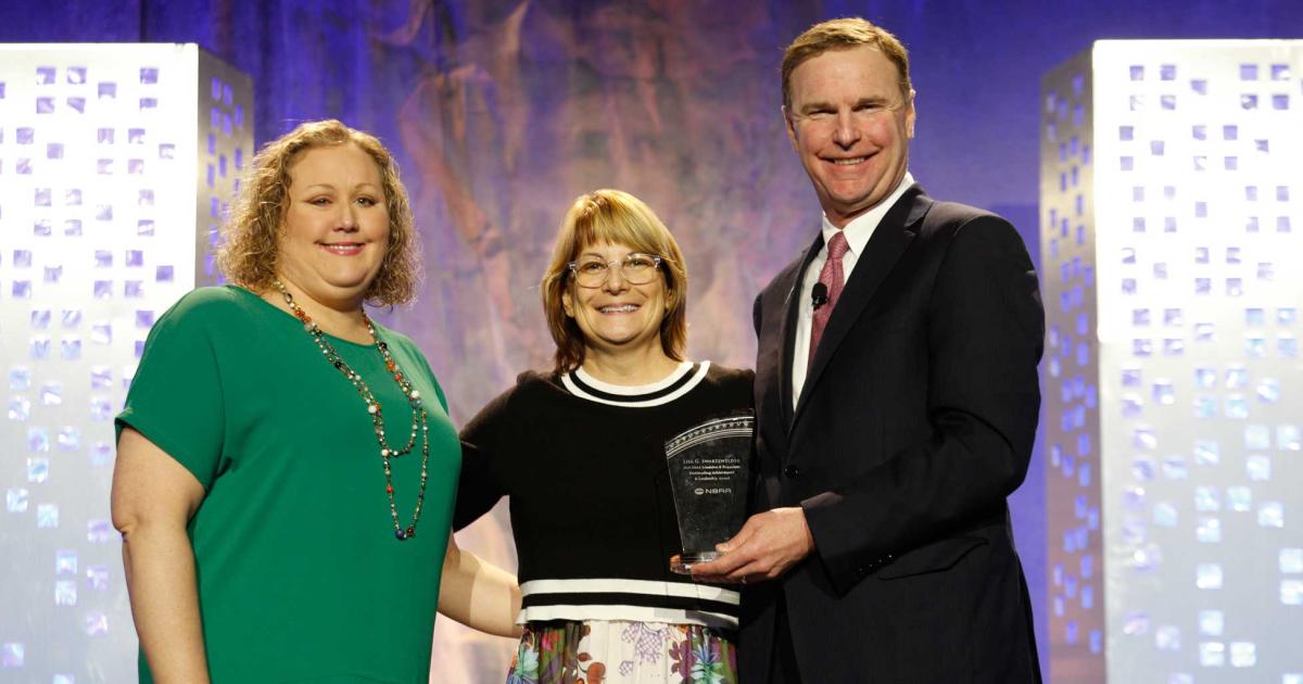 S&D 2018 Committee Chair Robyn Carpenter (l.) and NBAA president Ed Bolen present the 10th Annual NBAA Schedulers and Dispatchers Outstanding Achievement and Leadership Award to Lisa Swartzwelder, director of shuttle operations and flight administration at L Brands (Photo: NBAA).