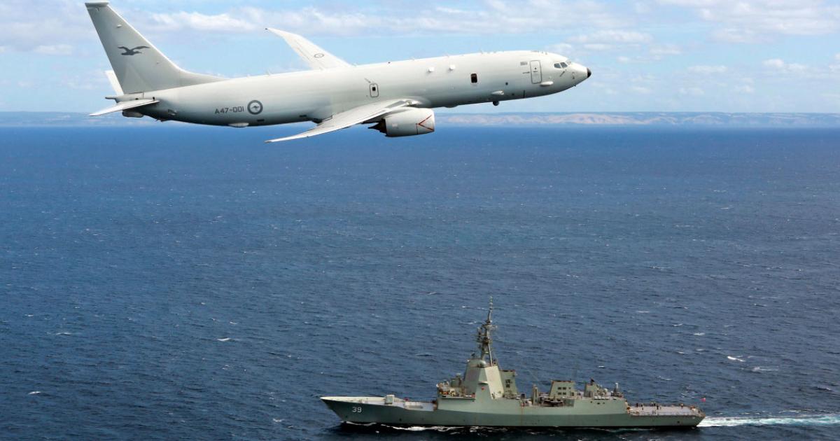 Wearing No. 11 Squadron’s albatross markings on the fin, a P-8A overflies a Hobart-class destroyer. (Photo: Cpl Craig Barrett/Australian Department of Defence)