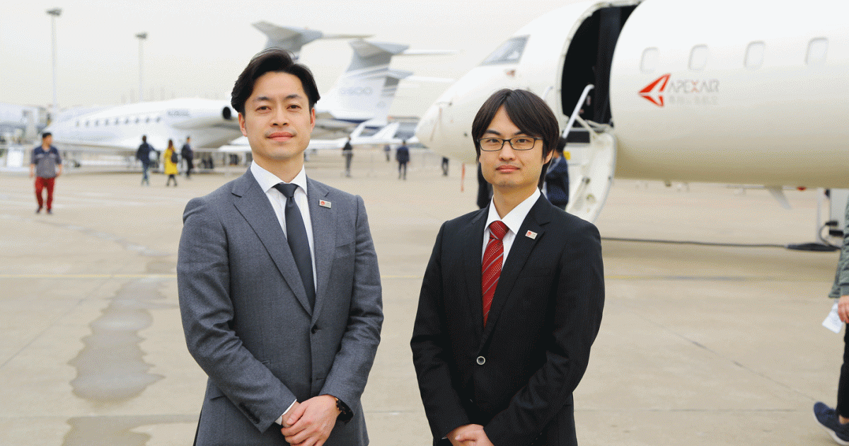 Shota Fukuzawa, chief official policy planning and research office (left) of Japan’s Civil Aviation Bureau, and Ryota Nagayo, from the JCAB’s policy planning and research office, toured the ABACE show site with JBAA’s 
Kazuyuki Tamura.
