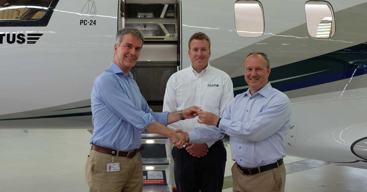 (L-R) Ignaz Gretener, Pilatus Aircraft's vice president for general aviation, hands over the keys at the delivery of the first PC-24 light jet to the Southeast U.S., with Andrew Barbalich, a pilot for purchaser Cajun Industries, and Scott Ducker, a sales representative with Pilatus dealer Epps Aviation.