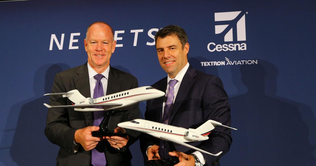 Textron chairman and CEO Scott Donnelly, l, and NetJets chairman and CEO Adam Johnson pose with models of the Cessna Citation Hemisphere and Longitude.