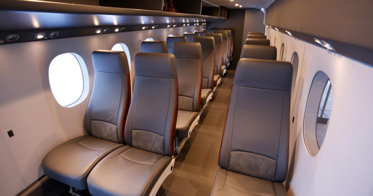 Textron’s SkyCourier passenger-configuration mockup shows a well-lit conventional one-plus-two seating layout with an offset aisle, neutral colors, and modern materials.  Photo: Cy Cyr
