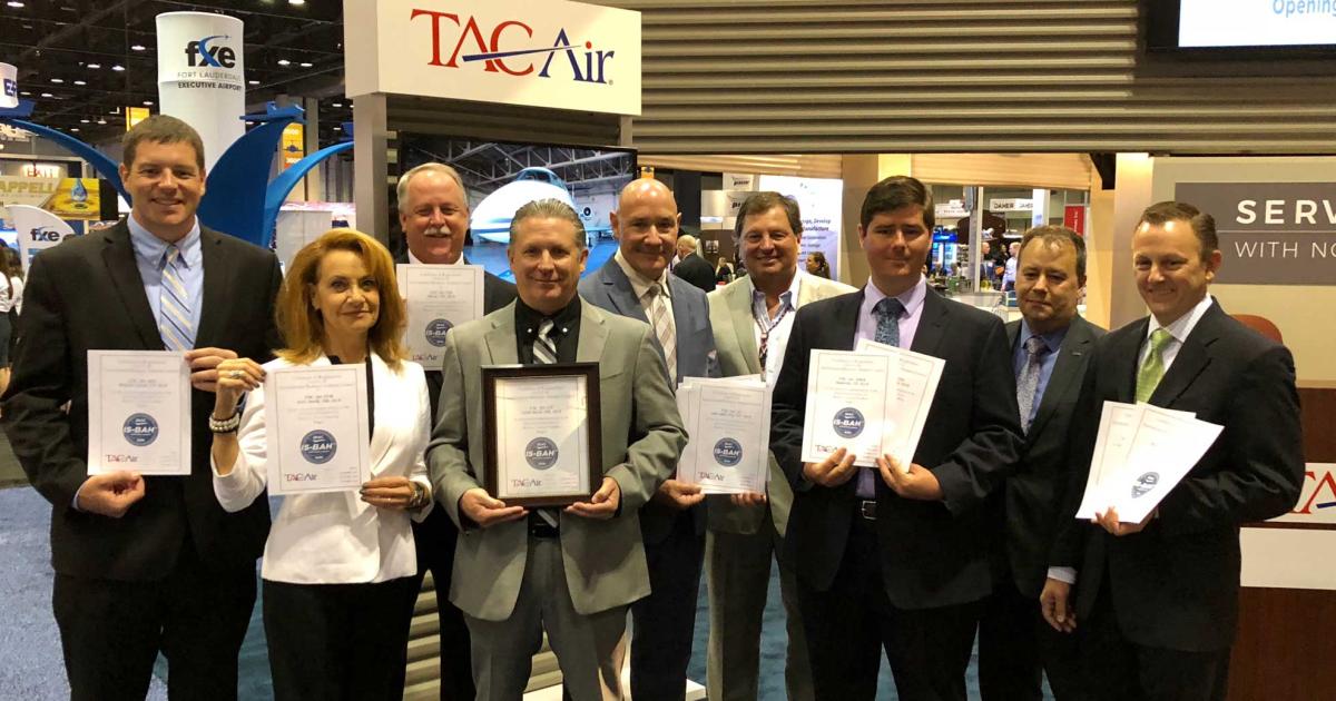At NBAA’s annual convention in Orlando, Terry Yeomans, IBAC’s IS-BAH program coordinator (second from right) presented Tac Air staff including Truman Arnold Companies (TAC) president and CEO Greg Arnold (fourth from right) and Tac Air vice president and COO Christian Sasfai with certificates indicating IS-BAH Stage 2 registration for each of the company’s 14 FBOs.