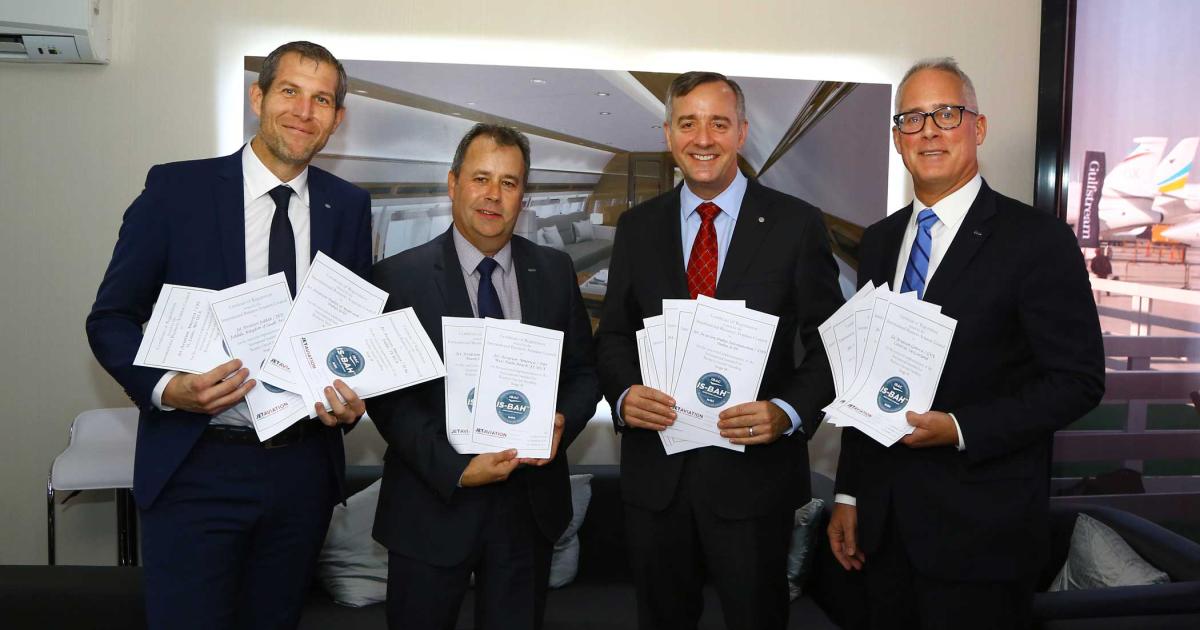 Displaying all 20 of Jet Aviation’s IS-BAH certificates are: Stefan Benz (l), senior v-p operations EMEA & Asia; Terry Yoemans, IBAC IS-BAH program director (center l); Rob Smith, Jet Aviation’s group president (center r); and Kurt Edwards, IBAC director general.