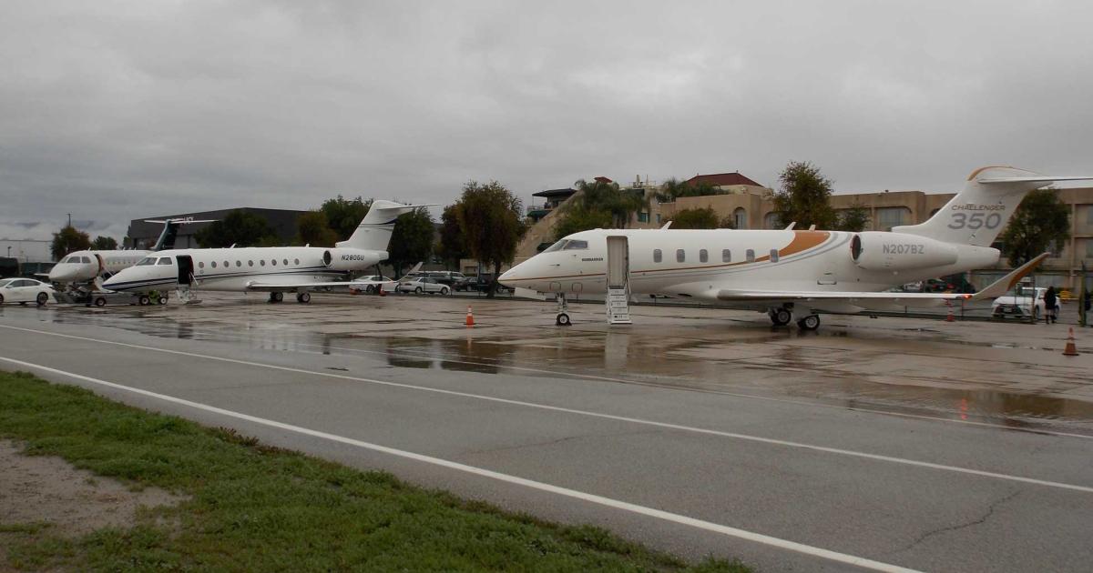 (l-r) An Embraer Legacy 500, Gulfstream G280, and Bombardier Challenger 350 await passengers for demonstration flights on sustainable alternative jet fuel at a rainy Van Nuys Airport in January. (Photo: Curt Epstein/AIN)