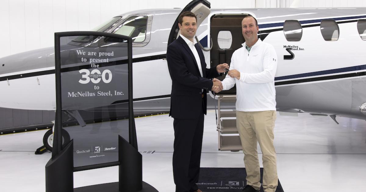 Textron Aviation's Steve Sperley hands over the keys of McNeilus Steel's new Citation CJ 4 to Levi McNeilus at a delivery ceremony yesterday in Wichita. (Photo: Textron Aviation)