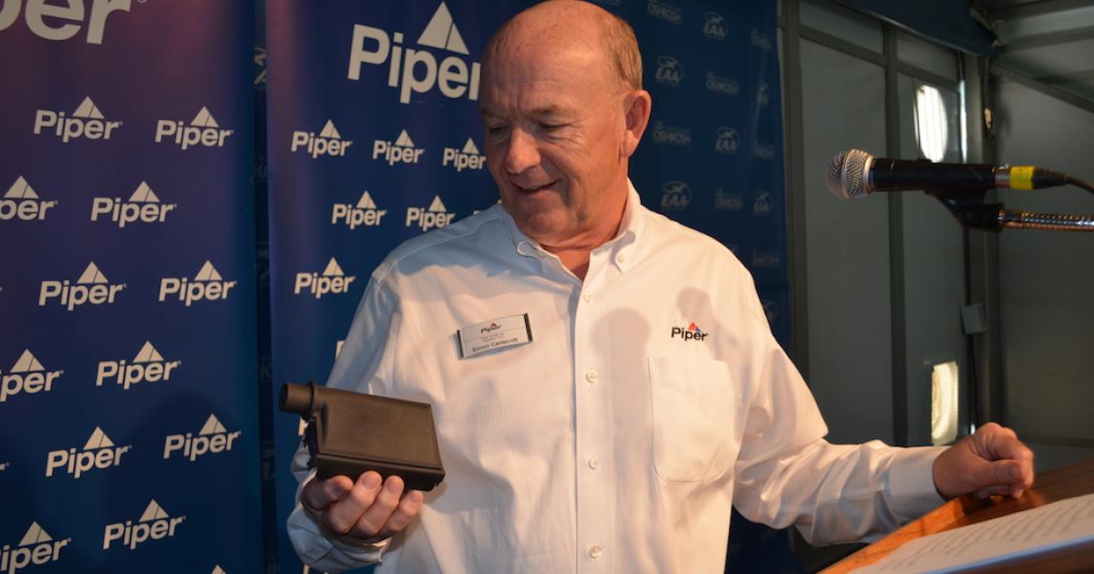 Piper president and CEO Simon Caldecott is impressed with the potential for additive manufactured parts, such as this duct from an M600 that he said costs 6 percent as much to manufacture as a traditionally made part. (Photo: Mark Phelps AIN)
