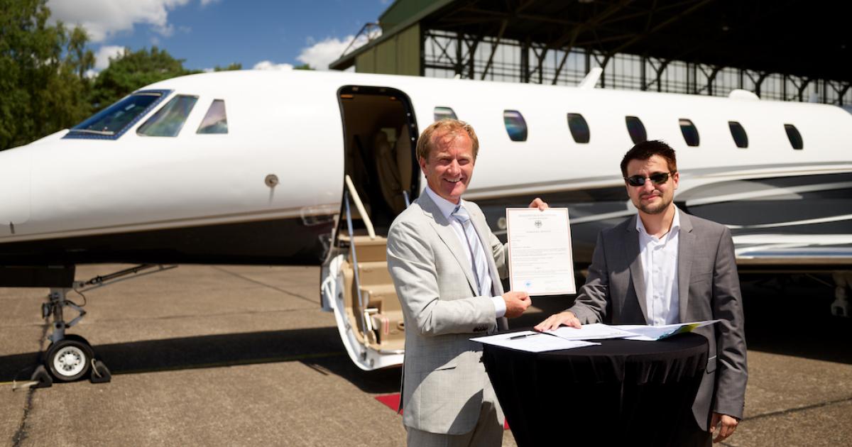 Exxaero accountable manager Roderick Buijs, left, accepts the company's air operator's certificate from Herr Emmanuel Kalogeris of the German Luftfahrt Bundesamt at Weeze Airport. (Photo: Exxaero)