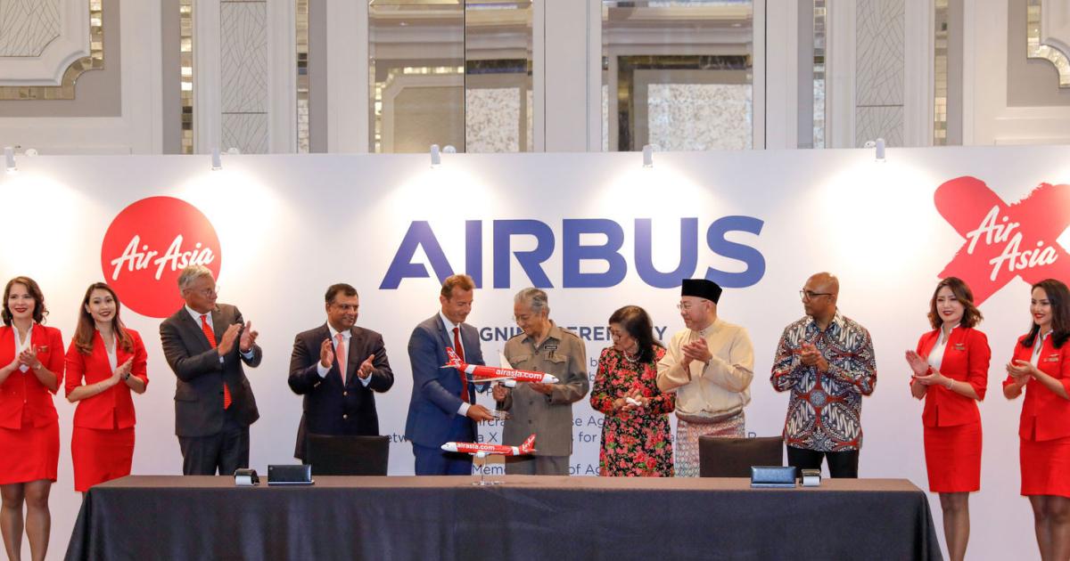 Left to right ( flanked by cabin crew): Christian Scherer, Airbus COO; Tony Fernandes, AirAsia Group CEO; Guillaume Faury, Airbus CEO; Mahathir Bin Mohamad, Prime Minister of Malaysia; Rafidah Aziz, chairman AirAsia X Berhad; Datuk Kamarudin Meranun, AirAsia Group executive chairman;  Bo Lingam, AirAsia Group president (Airlines).
