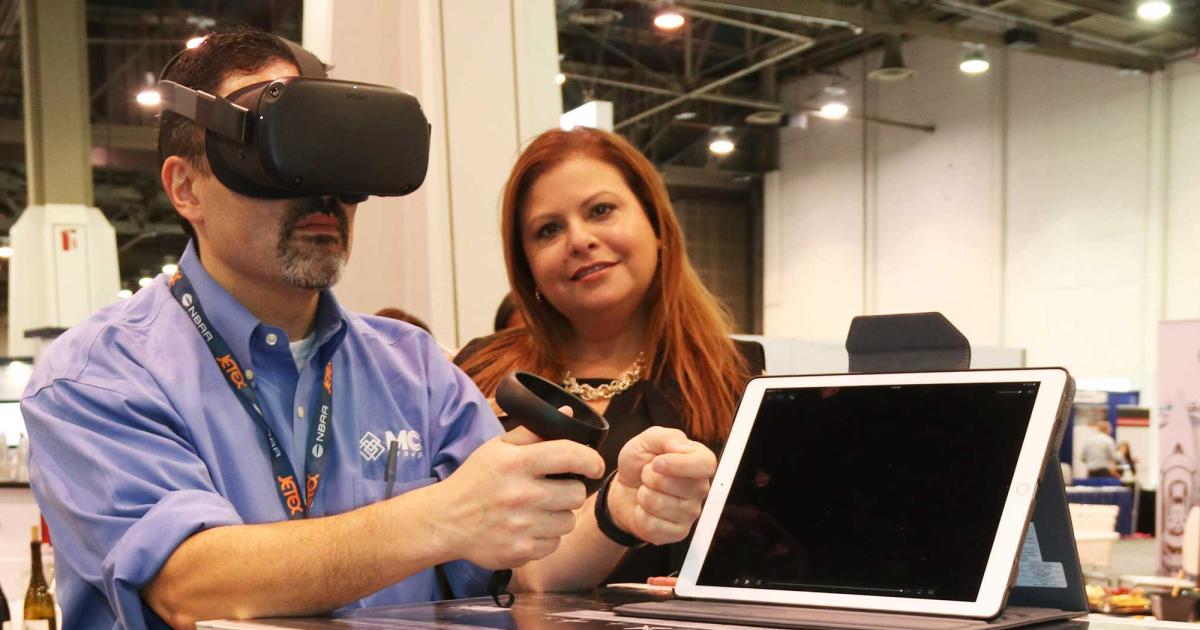 Sheltair’s Raquel Monge introduces a show attendee to her company’s new FXE hangar with a pair of virtual reality goggles.