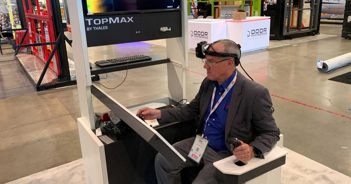 AIN editor in chief Matt Thurber tries his hand at flying a simulator using Thales’ TopMax wearable head-up display at the company’s booth.