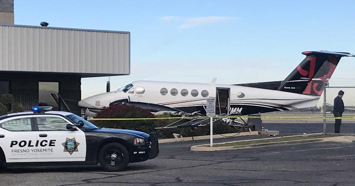 The 1979 Beechcraft King Air 200 was substantially damaged after a girl gained access to the general aviation area at Fresno Yosemite International Airport, somehow managed to start one of the turboprop's engines, and propel it into a fence and a building. (Photo: Jim Guy/The Fresno Bee)