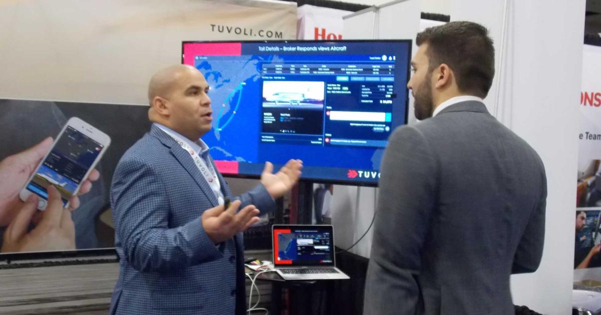Tuvoli regional sales director Henry Thompson (l.) demonstrates the company's charter booking and payment platform at its booth at NBAA's annual Schedulers & Dispatchers Conference this week in Charlotte, N.C. (photo: Curt Epstein)