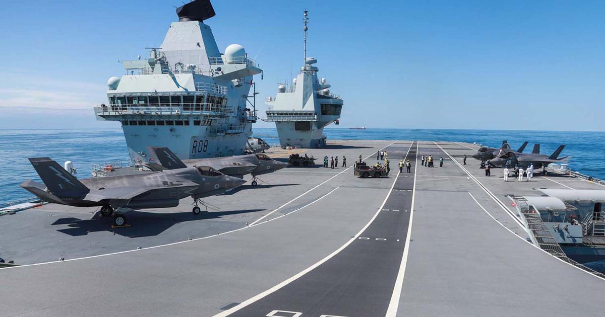 Four F-35Bs from No. 617 Squadron and a single Merlin stand on the flight deck of Queen Elizabeth during carrier trials in June. (Photo: Royal Navy)