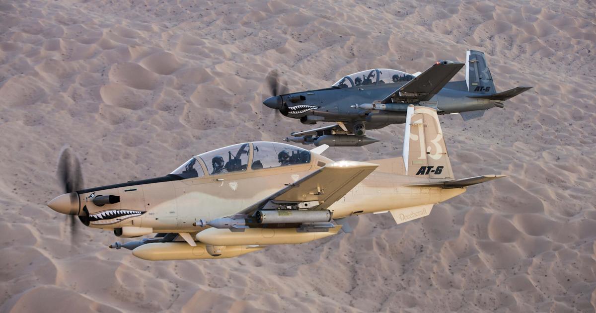 AT-6 Wolverine demonstrators are seen with laser-guided bombs, plus rocket pods on the aircraft in the foreground and gun pods on the example behind. [Photo: Textron Aviation Defense]