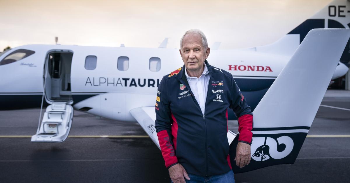 Red Bull motorsport consultant Helmut Marko stands in the foreground of Italian Formula One team Scuderia AlphaTauri's new HondaJet Elite. The Red Bull-sponsored F1 team now drives and flies with Honda. (Photo: Rheinland Air Service)