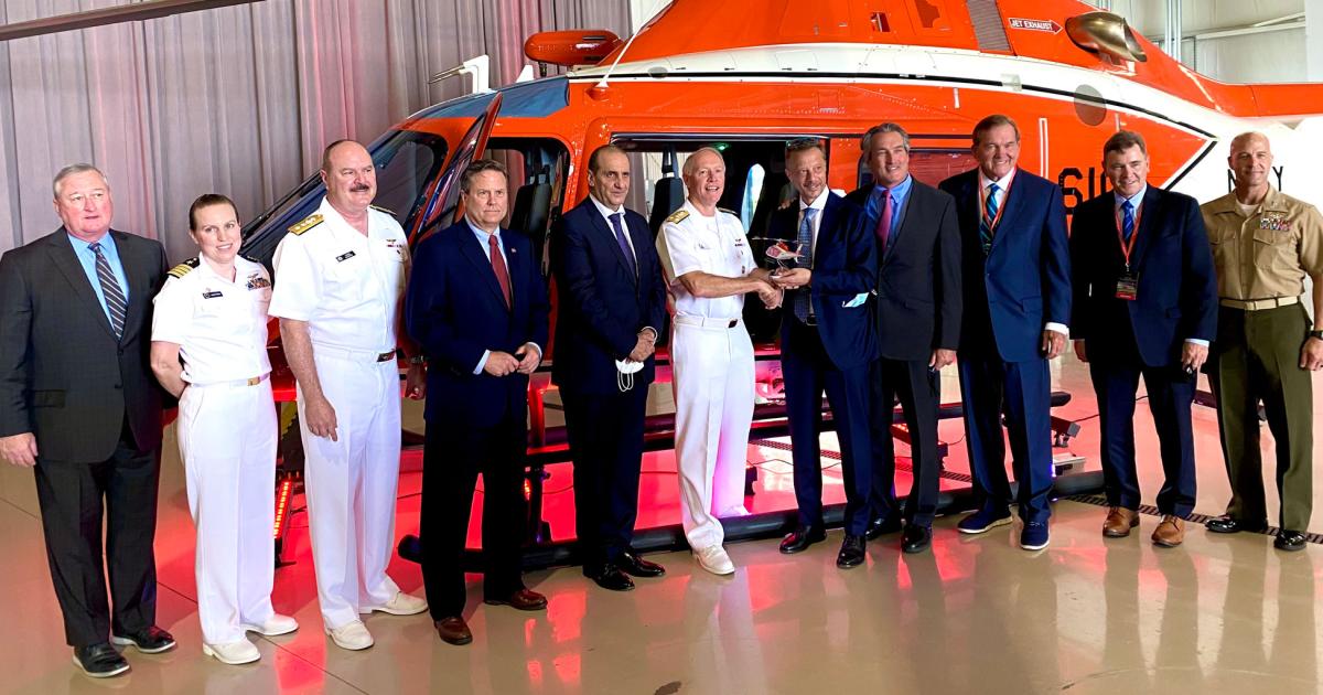 Amid a group of military officers, elected officials, and Leonardo executives, vice admiral Kenneth Whitesell (center), commander of U.S. Naval Air Forces, accepts a model of the new TH-73A training helicopter from Gian Piero Cutillo, managing director of Leonardo Helicopters, yesterday at the delivery ceremony for the first of the type. (Photo: Curt Epstein/AIN)