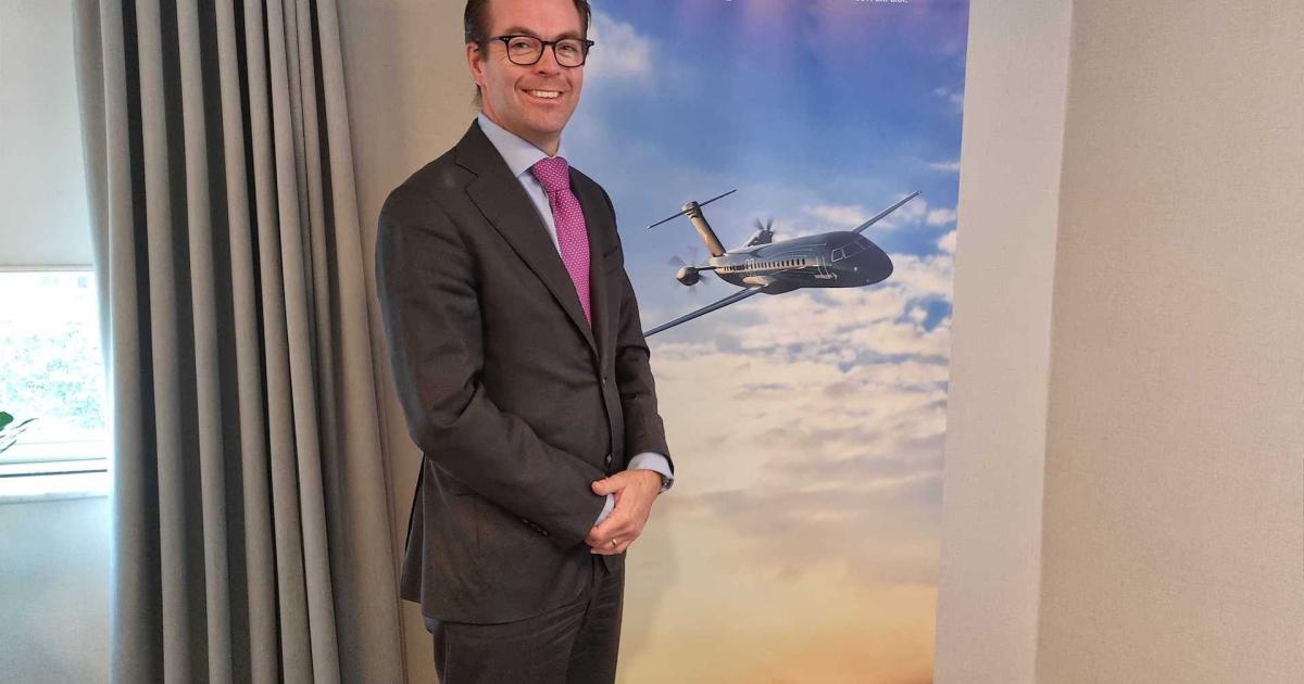 Arjan Meijer, CEO of Embraer Commercial Aviation, stands in front of a banner showing a rendering of the Brazilian OEM’s concept of a NextGen turboprop aircraft at the IATA AGM in Boston. (Photo: Cathy Buyck) 
