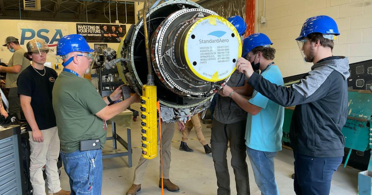 Pittsburgh Institute of Aeronautics Myrtle Beach staff and students prepare to mount a Garrett TFE731-3 engine donated by StandardAero on an engine stand. (Photo: Pittsburgh Institute of Aeronautics)