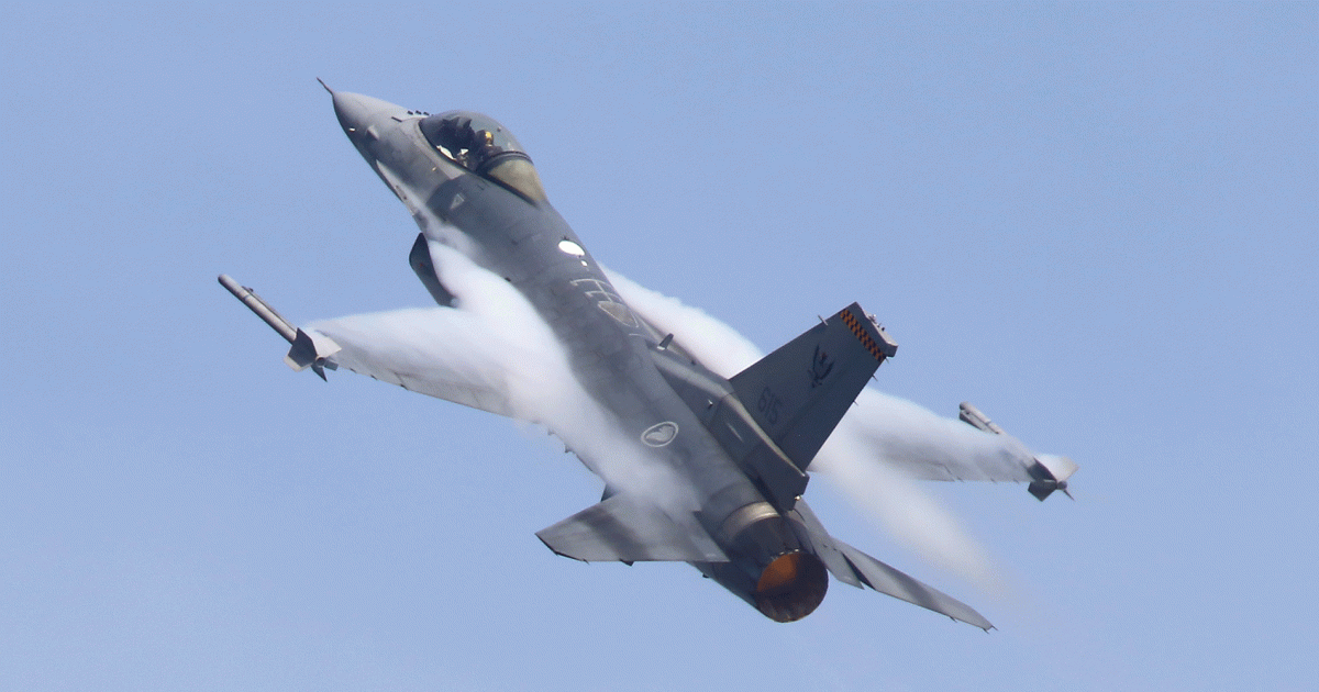 The Singapore Air Force Lockheed Martin F-16C fighter pulling g with afterburner lit during the pre-show demonstration of its acrobatic routine.