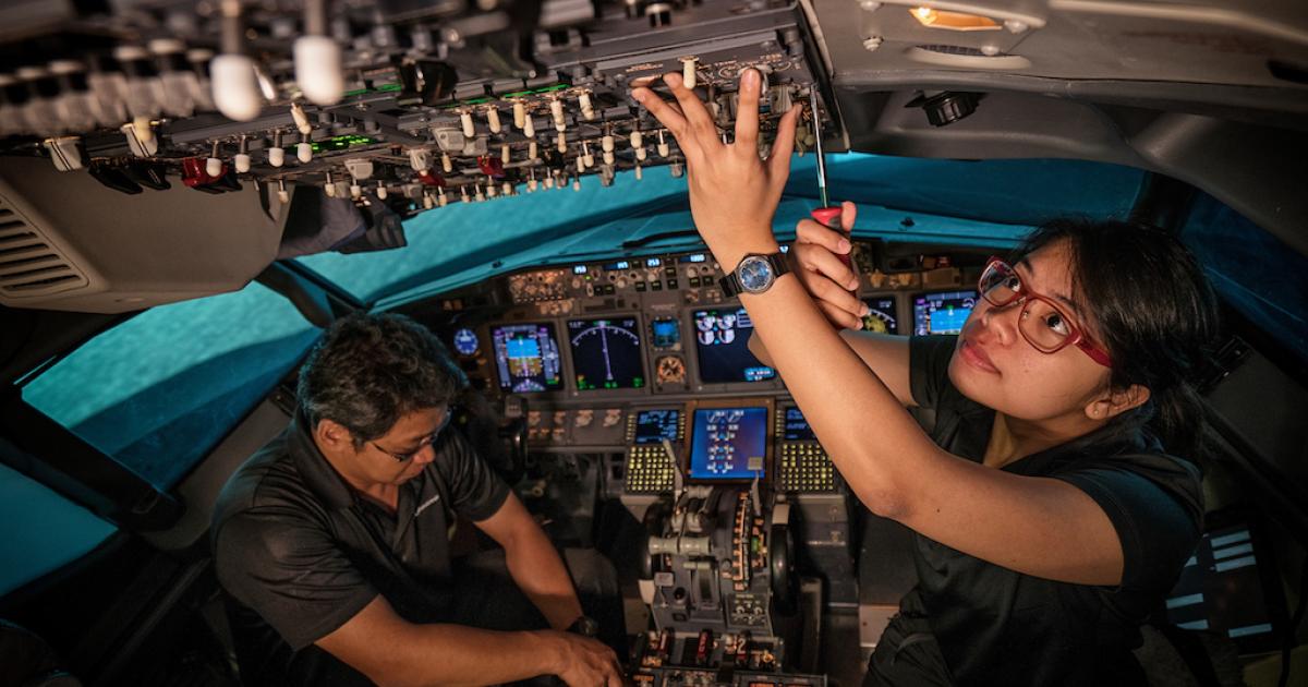 Melissa Sarijan (right) and Hirwan Bin Manap service a 737 flight simulator at the Boeing Commercial Training Solutions Singapore campus. (Photo: Boeing)

