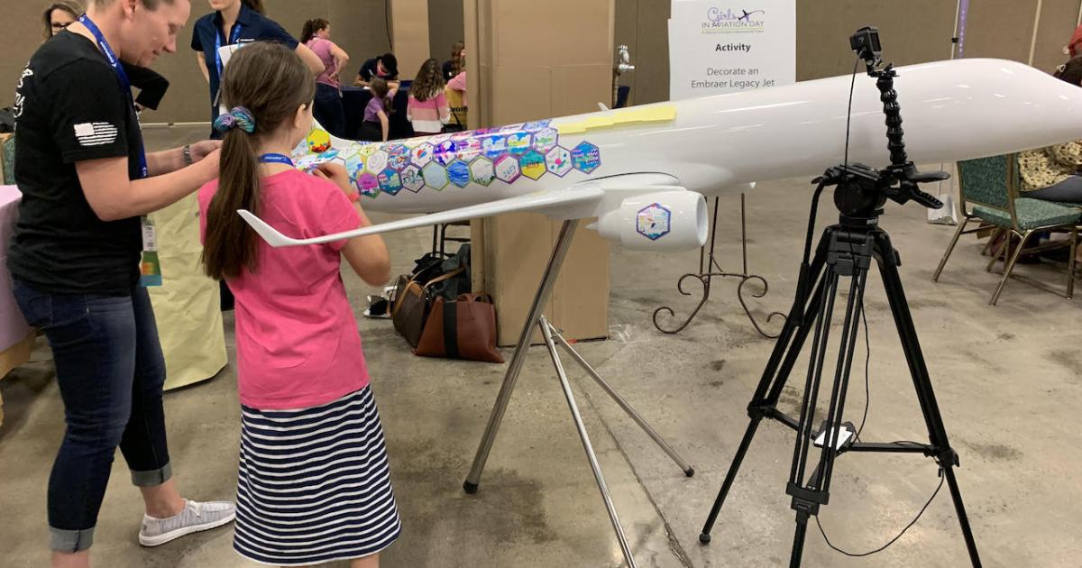 Among the activities at Girls in Aviation Day, held on the last day of 33d annual International Women in Aviation Conference, was the decoration of an Embraer Legacy. The colorful Legacy is to head to Nashville International Airport where it will be placed on display. (Photo: Kerry Lynch/AiN)