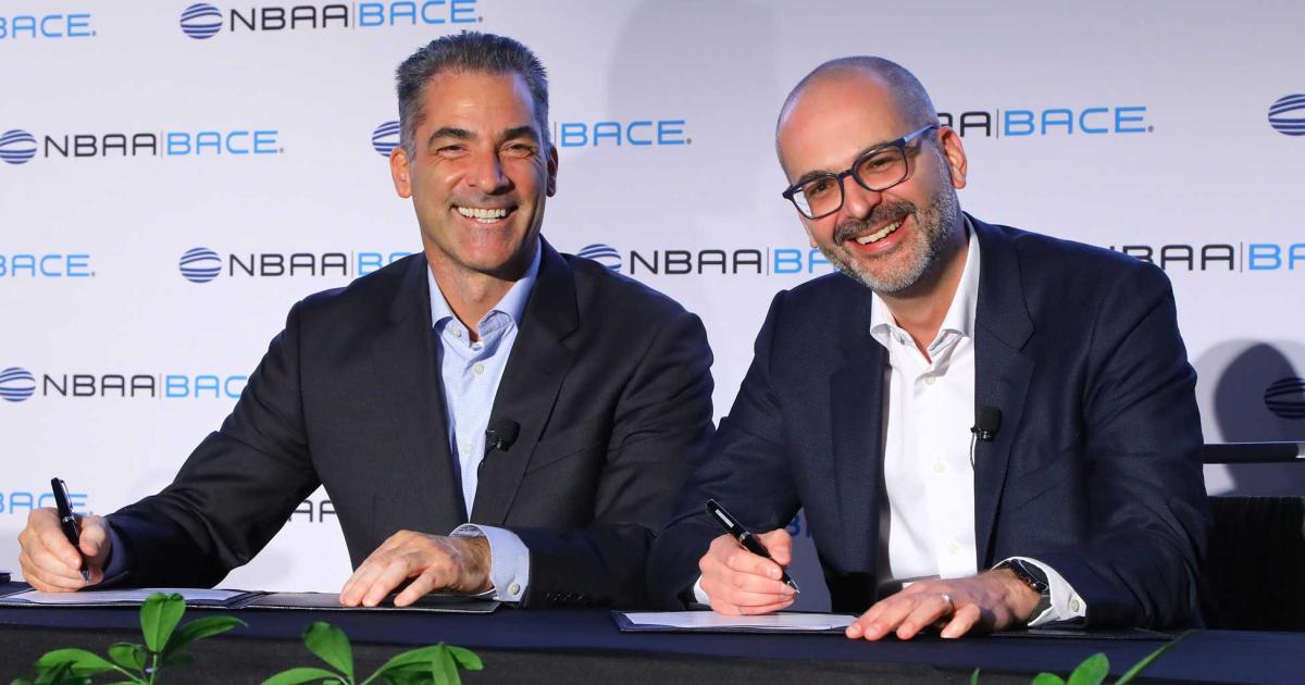 Signature Aviation CEO Tony Lefebvre (l.) and Jean-Christophe Gallagher, Bombardier's executive v-p of services, support and corporate strategy, sign an agreement on Monday at NBAA-BACE in Orlando. The deal will cover the totality of Bombardier's flight operations with SAF credits from Signature's book and claim program starting on January 1, 2023. (Photo: David McIntosh/AIN)