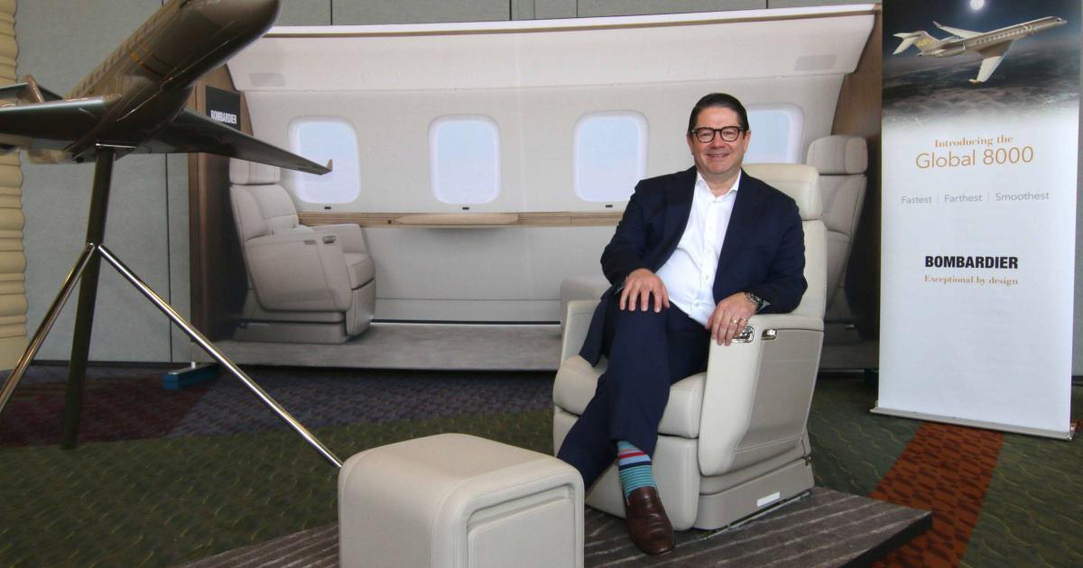 Bombardier president and CEO Éric Martel demonstrates features of the larger cabin design for the Global 7500 and 8000, including the Nuage cube, which doubles as a seat, stool, or small table.