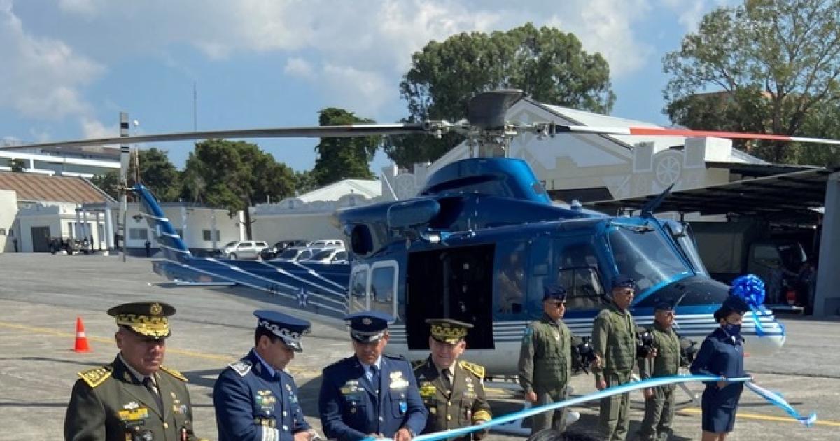 Guatemalan military personnel cut ribbon in front of Bell 412EPX during a ceremony at a ceremony at La Aurora International Airport