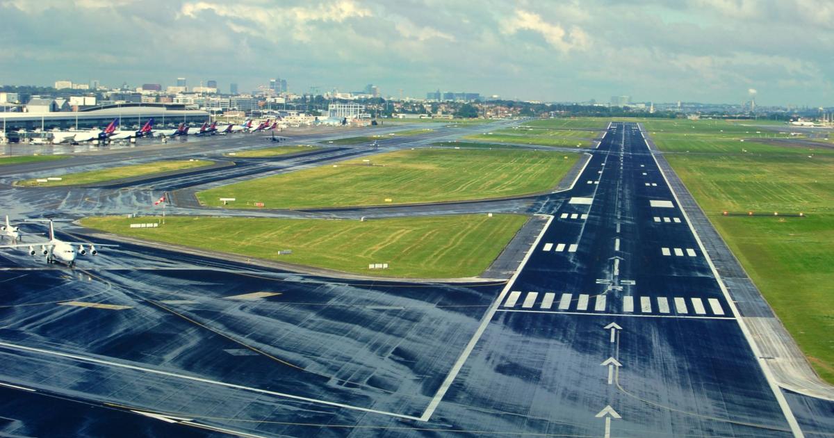 view of runway 25R at Brussels National Airport with airliners parked at gates in background