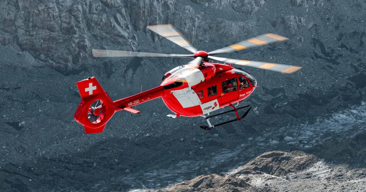 Rega Air Rescue Service Helicopter in flight over mountains in Swiss Alps