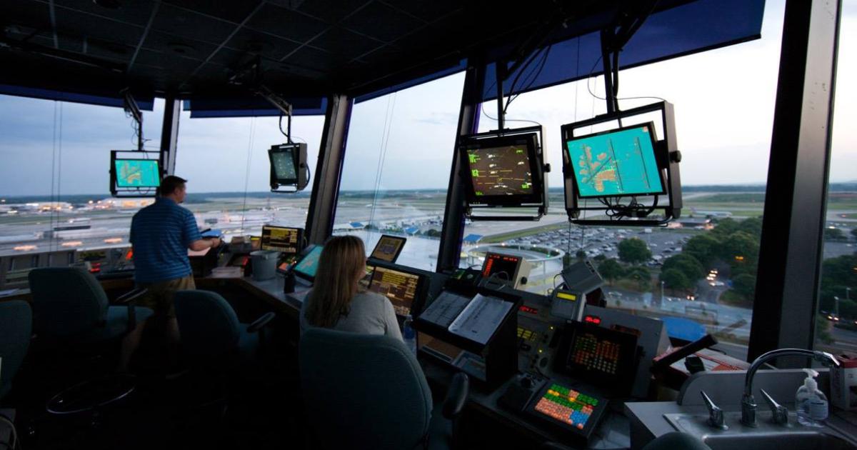 Air Traffic Controllers working in tower overlooking airport