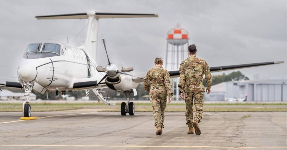 Military personnel walking toward U.S. Army King Air on airport ramp