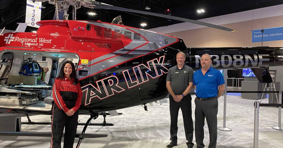 Global Medical Response employee, Bell Employee and Air Link air ambulance employee pose for photo with Bell air ambulance helicopter