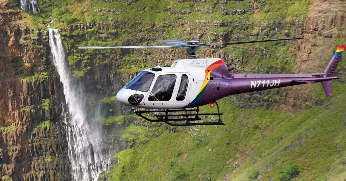 Jack Harter Helicopters Eurocopter AS 350 B2 in flight off Hawaiian coast with waterfall in background