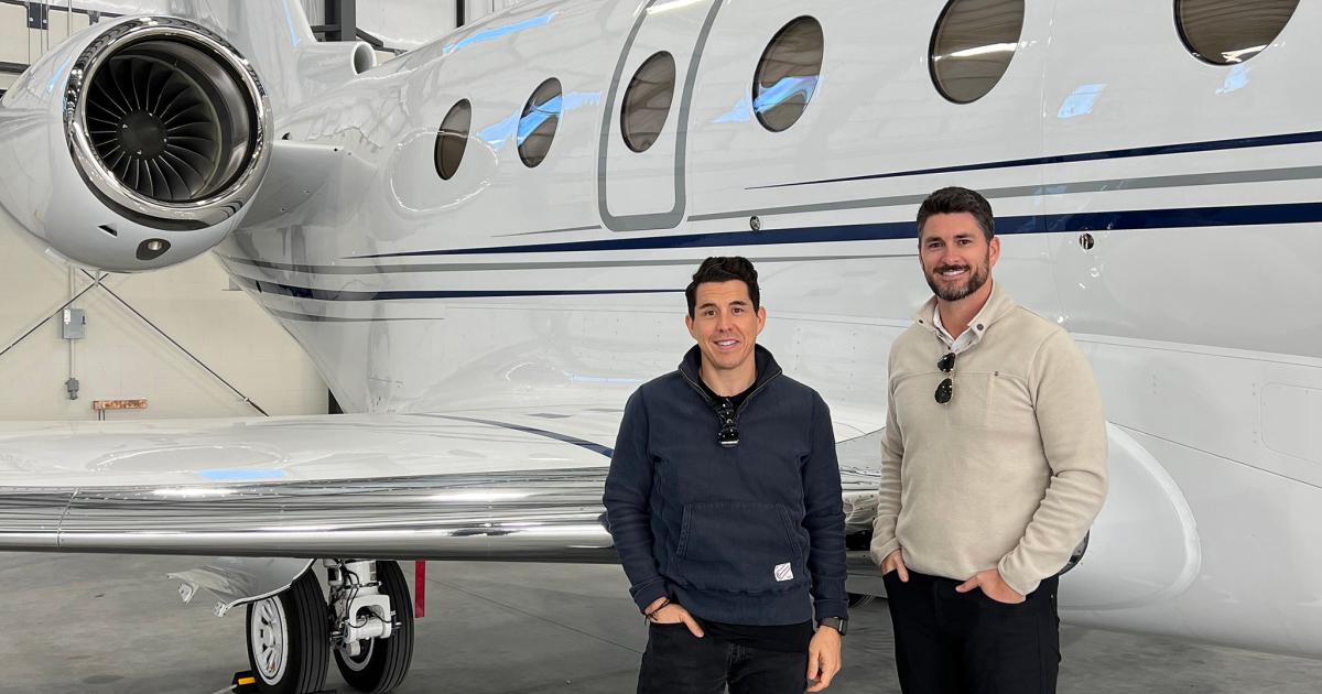 JetHQ's RJ Miller and Cole White pose in front of wing on Gulfstream business jet