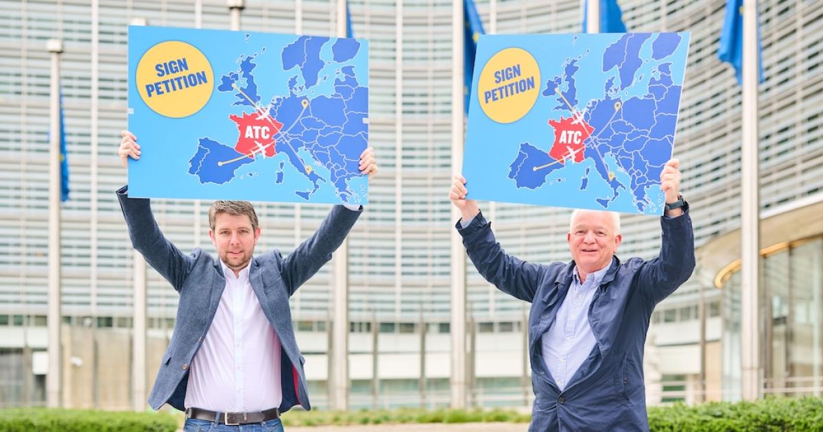 Ryanair director of operations Neal McMahon (left) and CEO Eddie Wilson hold signs calling for customers to sign a petition to allow for French overflights while air traffic controllers in the country stage strikes. 